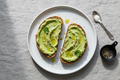 two slices of wholegrain toast with olive oil-based spread or avocado
